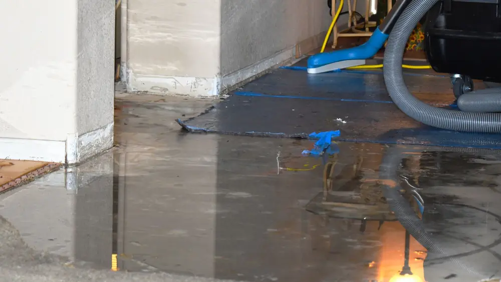 Extraction hose lying across a flooded concrete floor