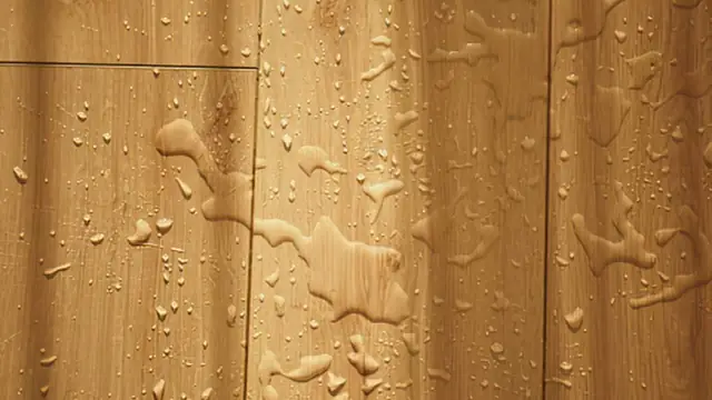 Water droplets on a wooden laminate floor surface